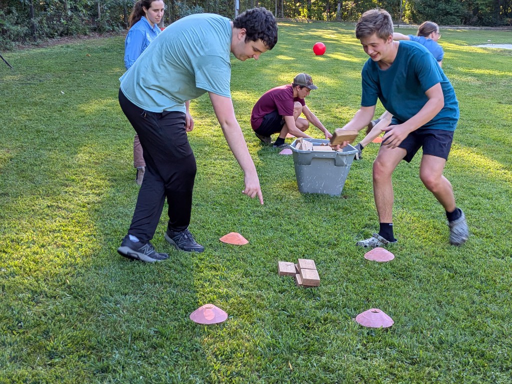 Students working together outdoors during a House System activity on the school lawn